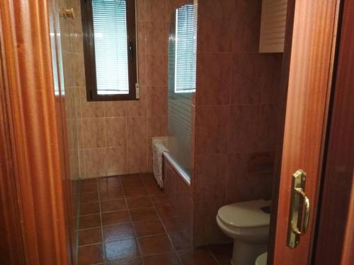 a bathroom with a toilet and a shower with a window at Estancia rural ideal con niños - Miraflores Sierra in Miraflores de la Sierra