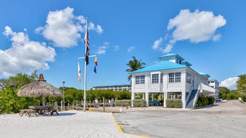a building on the beach with a flag and a picnic table at Reel Key Largo Escape Ocean Pointe 5209 in Key Largo