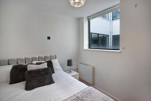 Un dormitorio blanco con una cama y una ventana. en 2-Bed Apartment Sleeps 4 Free Parking, en Croydon