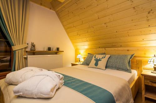 a bedroom with a bed in a wooden ceiling at Rezydencja Na Szymoszkowej in Zakopane