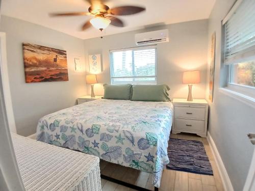 a bedroom with a bed and a ceiling fan at Sand Dollar Updated Kitchen Washer Dryer On River 1 Mile to Beach Sleeps 4 in Bonita Springs