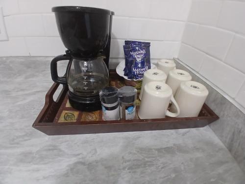 a coffee maker sitting on a wooden shelf with cups at Sand Dollar Updated Kitchen Washer Dryer On River 1 Mile to Beach Sleeps 4 in Bonita Springs