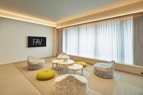 a living room with chairs and a table and a window at FAV LUX Kagoshima Tenmonkan in Kagoshima