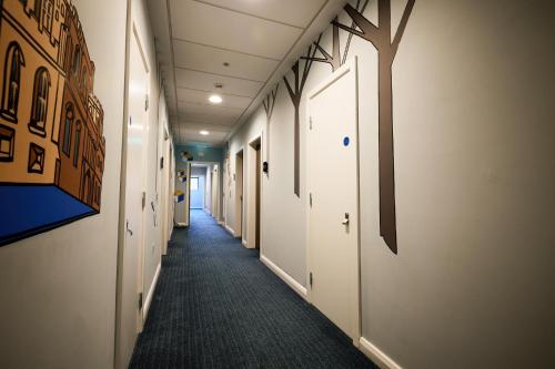 a hallway of an office with a tree on the wall at Holiday Inn - the niu, Loom Manchester North by IHG in Manchester