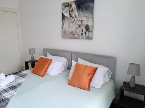 a bedroom with a bed with orange and white pillows at Large 2 beds flat- 3min walk from centre in Reading