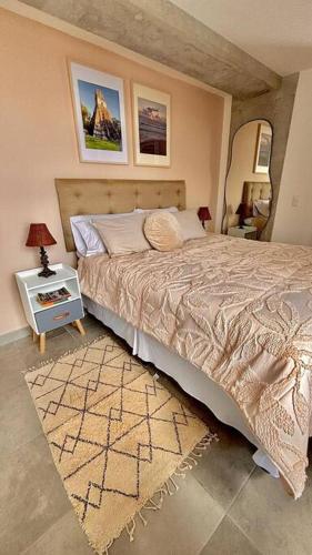 a bedroom with a bed and a table with a lamp at Wanderer estilo boho chic in Las Victorias
