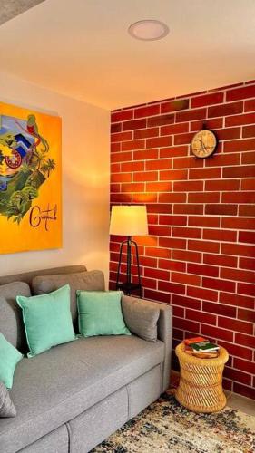 a living room with a couch and a brick wall at Wanderer estilo boho chic in Las Victorias