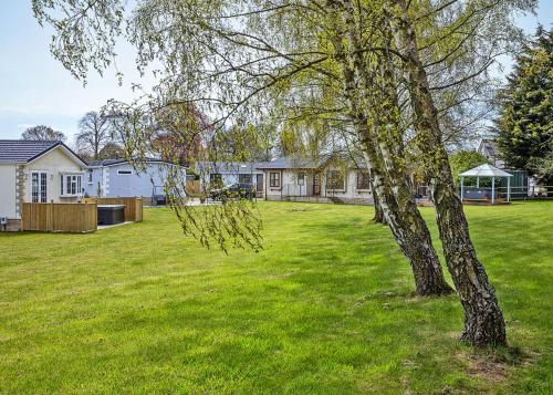 a tree in the middle of a yard with houses at Cleveland Hills View Holiday Park in Middleton upon Leven