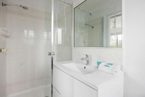 a white bathroom with a sink and a shower at 4 Blairgowrie Apartments 4 of 2 Martin Street in Peregian Beach in Peregian Beach