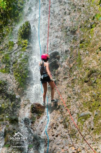 a woman is on a rope in front of a waterfall at GOLDEN TREE MINDO ECO-LODGE in Mindo