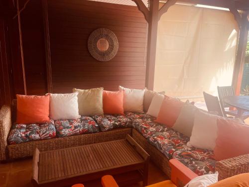 a couch with pillows on a porch at Love Guadeloupe in Sainte-Anne