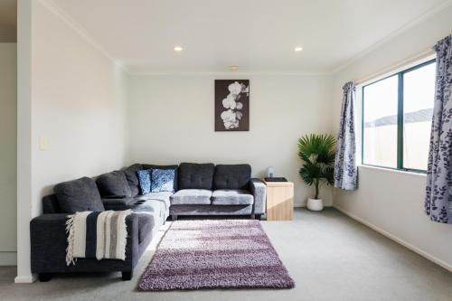 a living room with a couch and a rug at Camelot Motor Lodge and Conference Centre in Palmerston North