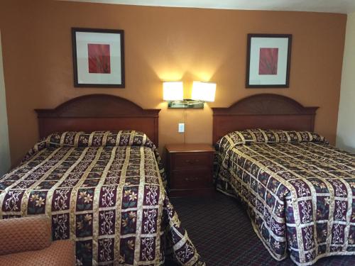 a hotel room with two beds and two lamps at Hacienda Motel in Yuma
