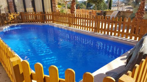 a swimming pool with a wooden fence around it at Masia Pau Prat in Lliçà d'Amunt