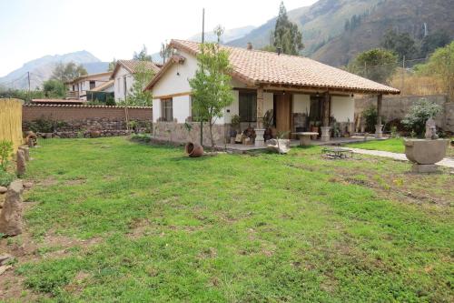 a house with a grass yard in front of it at casa de campo-arin in Huaran