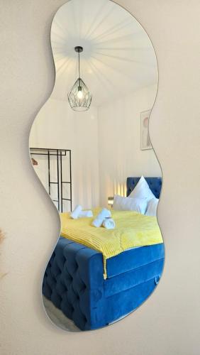 a mirror on a wall with a bed in a room at Design-Apartment I Boxspring I Nespresso I Balkon I Basel 10 km I Parkplatz in Eimeldingen