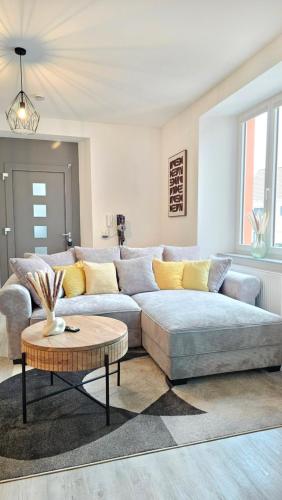 a living room with a couch and a table at Design-Apartment I Boxspring I Nespresso I Balkon I Basel 10 km I Parkplatz in Eimeldingen