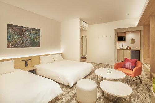 a hotel room with two beds and a table at FAV LUX Kagoshima Tenmonkan in Kagoshima