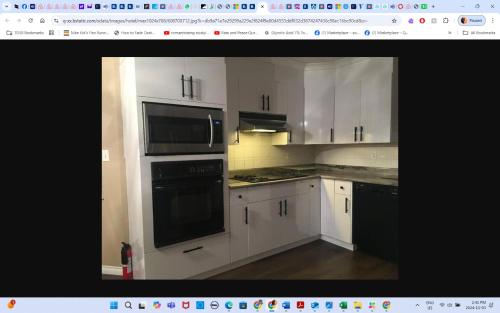 a kitchen with white cabinets and black appliances at Main floor room 4, 22 minute from airport in Edmonton