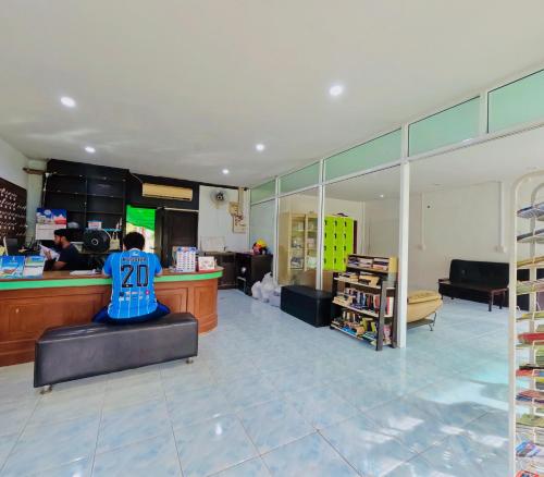 una persona seduta al bancone in un negozio di Lanta Palm Beach Resort , Beach Bungalow - Koh Lanta a Ko Lanta