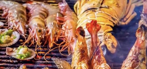 a bunch of seafood being cooked on a grill at Natural Villas Na Jomtien Pattaya Private Pool in Bang Sare
