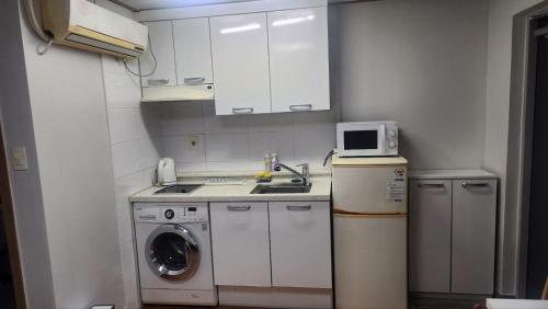 a small kitchen with a washing machine and a microwave at Kiman09 in Seoul