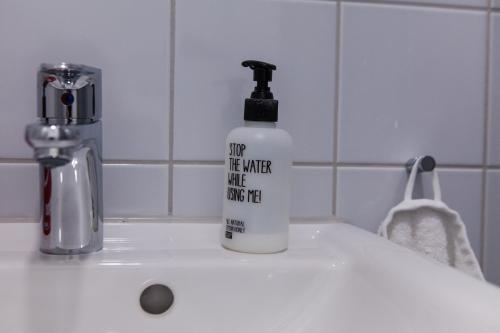 a bottle of soap sitting on a bathroom sink at Apartment&Rooms near Brandenburg Gate in Berlin