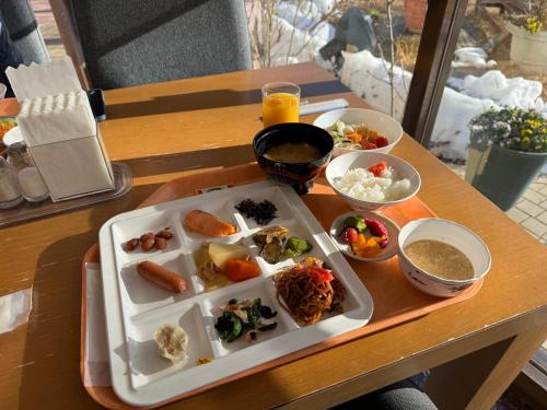 a tray with a plate of food on a table at Ashiwada Hotel in Fujikawaguchiko