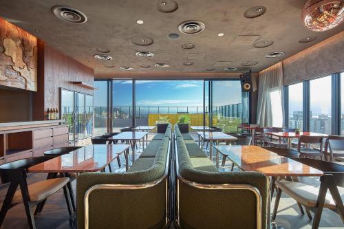 a restaurant with tables and chairs and large windows at FAV LUX Kagoshima Tenmonkan in Kagoshima