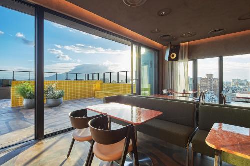 a restaurant with a balcony with a view of the city at FAV LUX Kagoshima Tenmonkan in Kagoshima