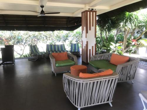 a lobby with chairs and tables and palm trees at The Ananyana Beach Resort by SMS Hospitality in Panglao