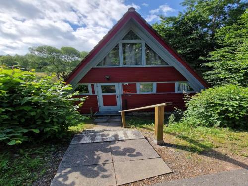 a red house with a bench in front of it at Holiday Home in Germany with Scenic Views in Ronshausen