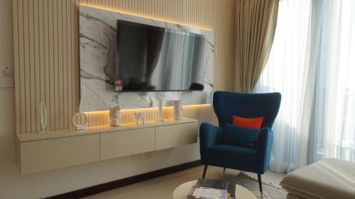 a room with a tv and a blue chair at Colombo, Trizen Luxury Apartments, Sri Lanka in Colombo