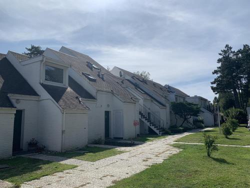 a row of white houses with a roof at Green Country in Hardelot-Plage