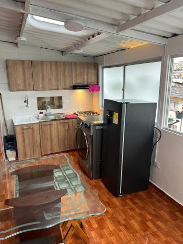 eine Küche mit einem schwarzen Kühlschrank und einem Herd in der Unterkunft Apartamento Barrio la Argentina vía principal 302 in Manizales