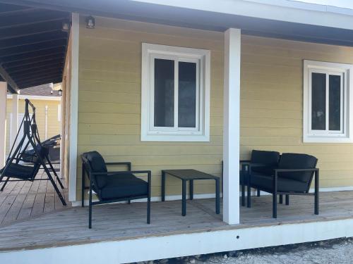 a porch with chairs and a table on a house at SANDY BOTTOM COTTAGES in Mount Thompson