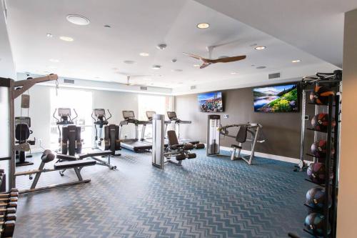 a gym with several tread machines and a flat screen tv at 3 Miles to Disney Heated Pool CnvntnCtr Jacuzzi in Fullerton
