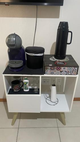 a white shelf with a coffee maker and a pot on it at Quarto privativo próxima a Arena Opus in São José
