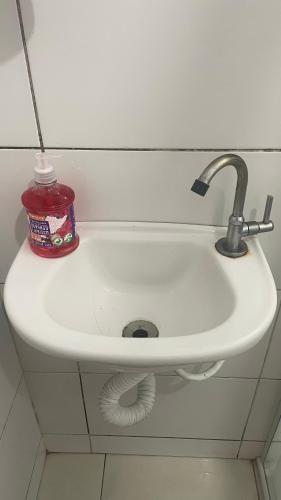 a white sink in a bathroom with a red container at Quarto privativo próxima a Arena Opus in São José
