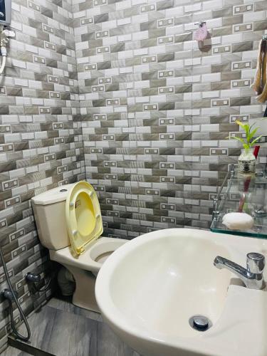 a bathroom with a white toilet and a sink at Villa Amorino in Galle