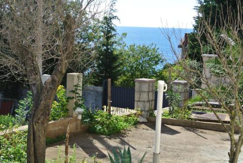 a garden with a fence and the ocean in the background at Apartments Klara in Utjeha