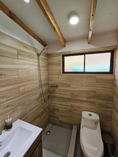 a bathroom with a toilet and a sink and a window at La Estancia del Molle in El Molle