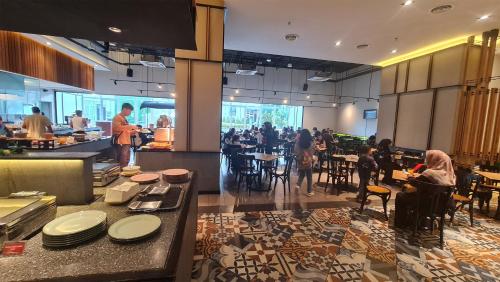 a restaurant with people sitting at tables in a cafeteria at Genting Windmill Homestay in Genting Highlands