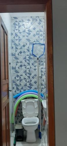 Baño pequeño con aseo y pared en Bela Mar Mongaguá, en Mongaguá