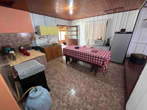 a kitchen with a table in the middle of a room at Casa Tangerina - Lago Pinhal in Rio dos Cedros