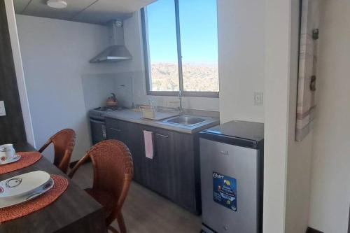 eine Küche mit Spüle und einem Tisch mit Stühlen in der Unterkunft Penthouse Titanium Mac Mini in La Paz
