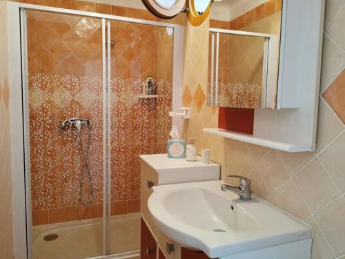 une salle de bain avec un lavabo et une douche dans l'établissement Appartement au calme avec piscine & salle de sport, à Saint-Julien