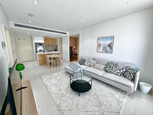 a living room with a couch and a table at Cosy 2-Bedroom Apartment, Homebush NSW 2140 in Sydney