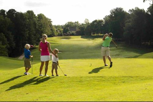 a family playing golf on a golf course at Beautiful home near Carowinds, Ballantyne in Fort Mill