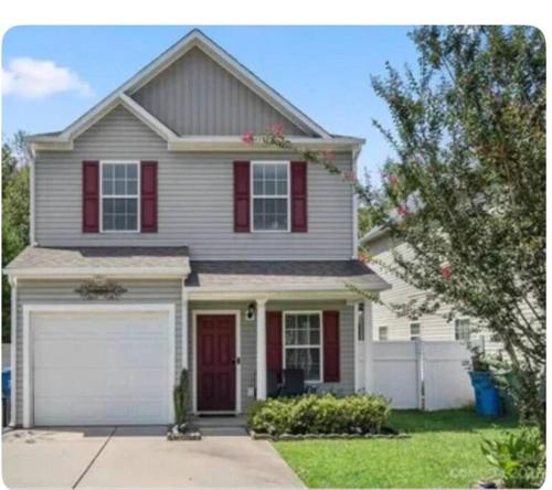 a white house with red shutters and a garage at Beautiful home near Carowinds, Ballantyne in Fort Mill
